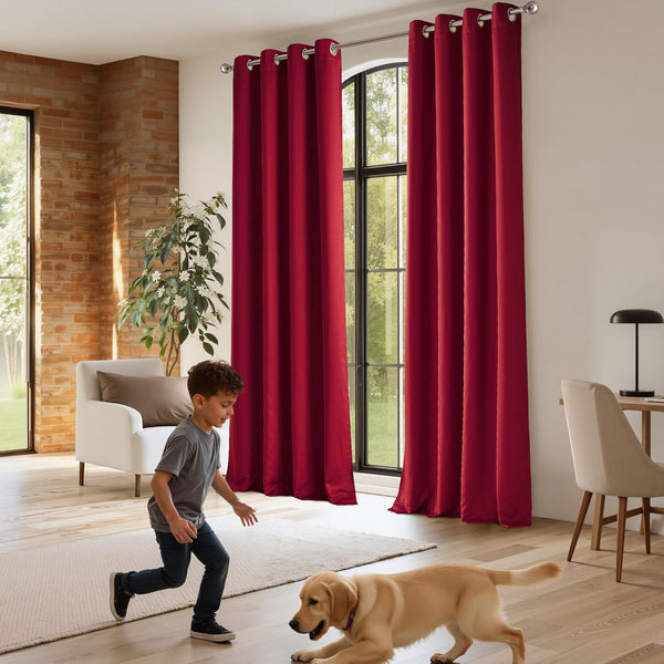 Deep red grommet top curtains with silver rings elegantly cover large windows in a modern living room.
