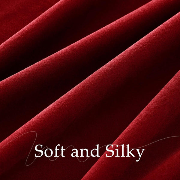 Close-up view of deep red velvet fabric with soft, plush texture and gentle folds.