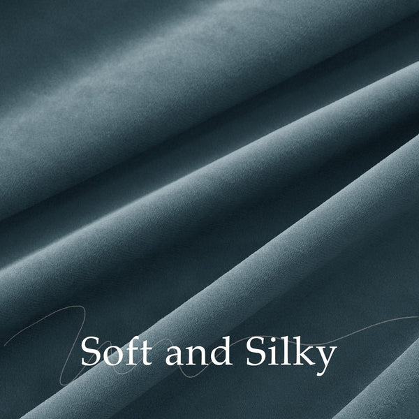 Close-up of a deep teal soft and silky velvet fabric with elegant drapes.