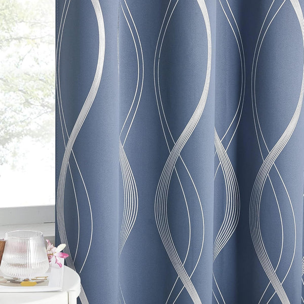 Dusty blue window curtain with a modern abstract wavy white line pattern, hanging in a room.
