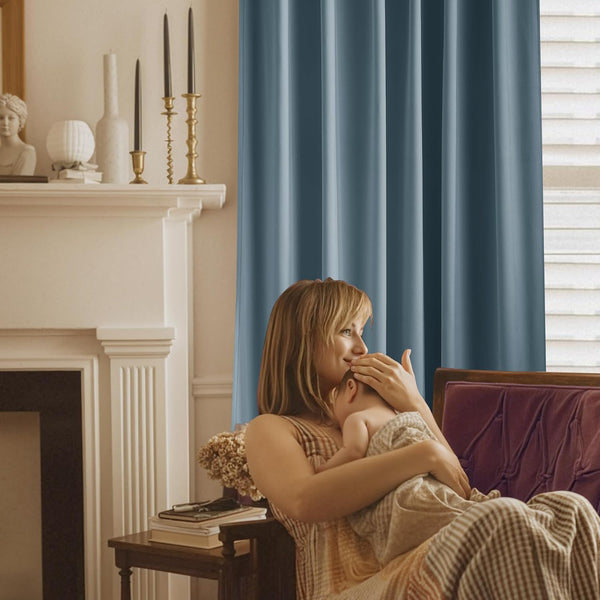 Dusty blue blackout window curtains with smooth, vertical pleats create a private, serene atmosphere.