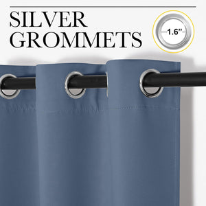 Close-up of dusty blue curtains with 1.6-inch silver grommet tops hanging on a black rod.