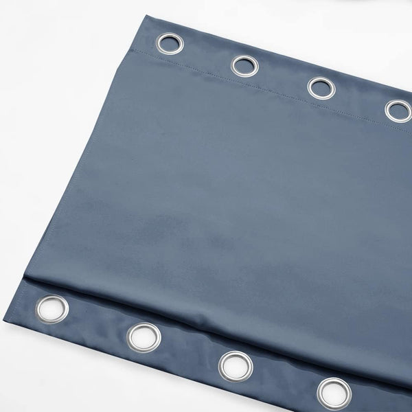Thick dusty blue fabric blackout curtain panel with large silver metal grommets along the top.