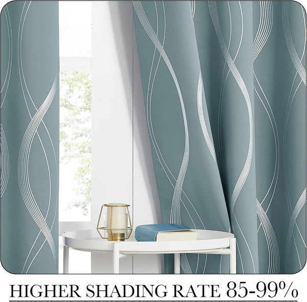 Dusty blue blackout curtains with modern white wavy line pattern elegantly draped by a window.