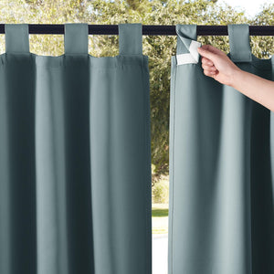 Hand opening hook and loop fastener on dusty blue outdoor tab top curtain.