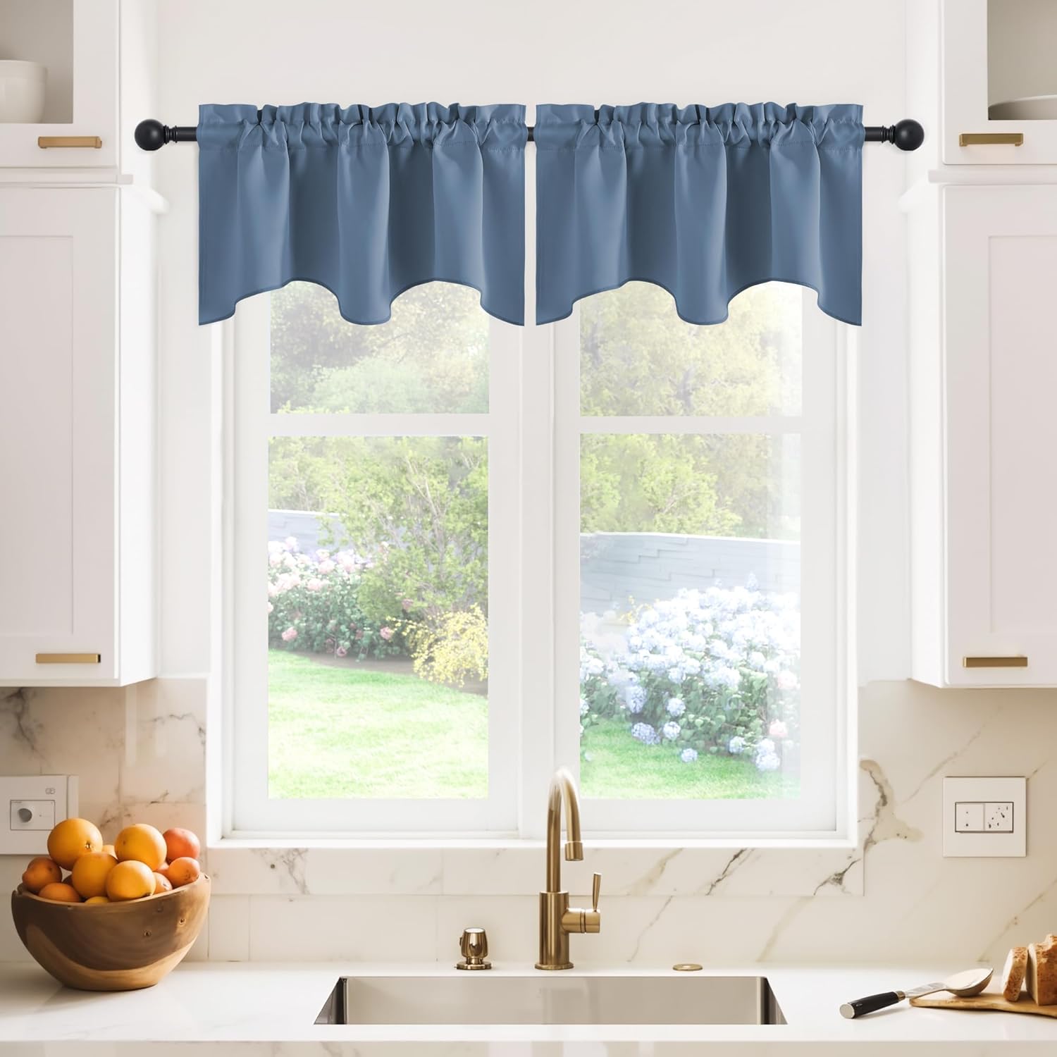 Dusty blue valance curtain with gathered top and scalloped hem, hung over a modern kitchen window.