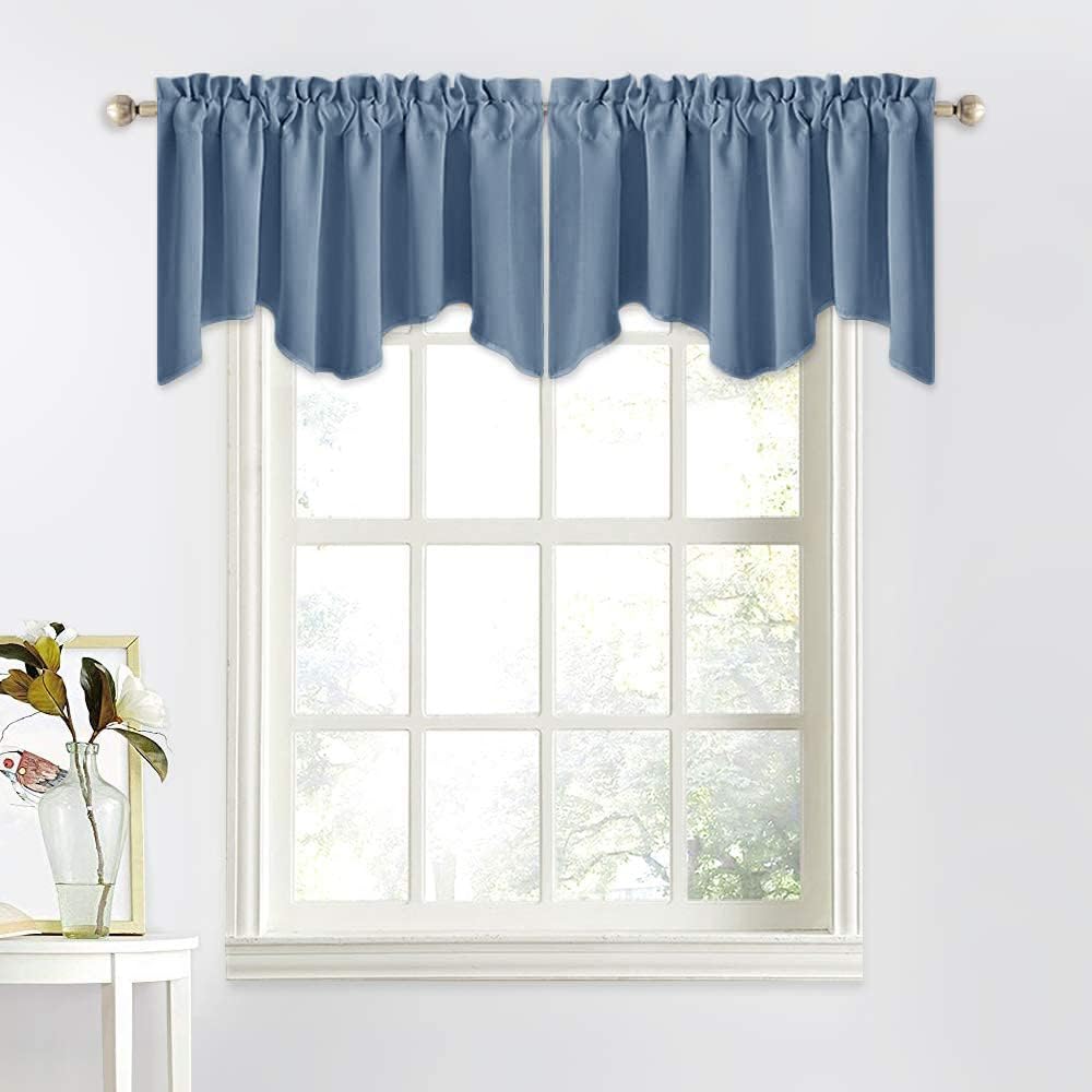 Dusty blue fabric valance with a scalloped hem, hung on a silver rod over a white window.
