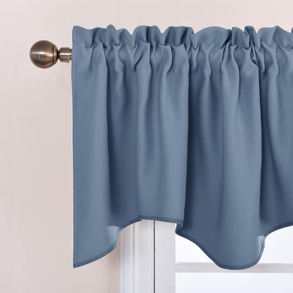 A dusty blue rod pocket valance with a ruffled top and a decorative scalloped bottom edge, displayed on a bronze curtain rod.