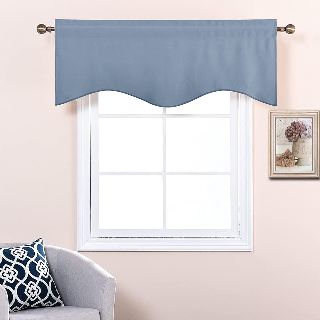 Dusty blue window valance with a scalloped bottom edge, hung on a bronze rod above a white window frame.