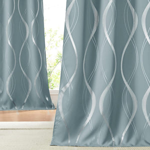 Dusty blue curtains with a prominent silver metallic wavy pattern, partially obscuring a window.