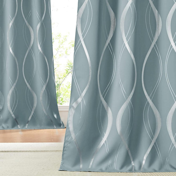 Dusty blue curtains with a prominent silver metallic wavy pattern, partially obscuring a window.