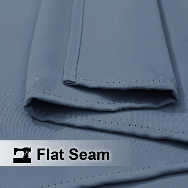 Close-up of dusty blue woven fabric showing a neatly sewn flat seam with fine stitching.