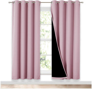 Dusty rose pink blackout grommet top curtain panels on a window, one showing black lining.