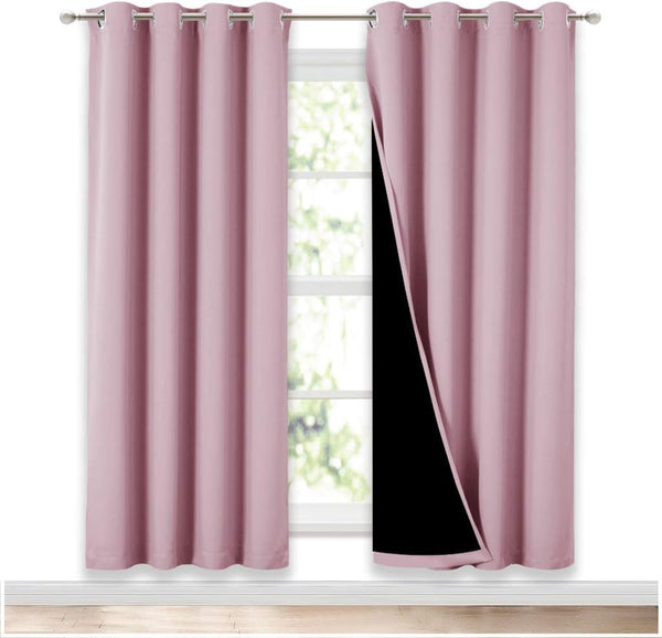Dusty rose pink blackout grommet top curtain panels on a window, one showing black lining.