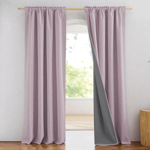 Dusty rose linen blackout curtains with rod pocket top and grey lining, hanging by a window.