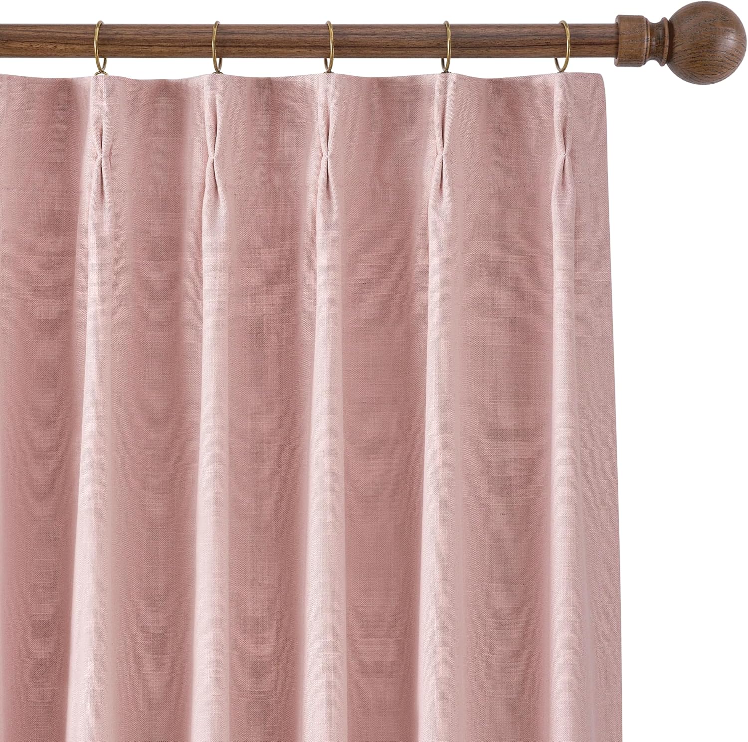 Dusty rose textured linen curtain with a pinch-pleat top, hanging from a dark wood rod and brass rings.