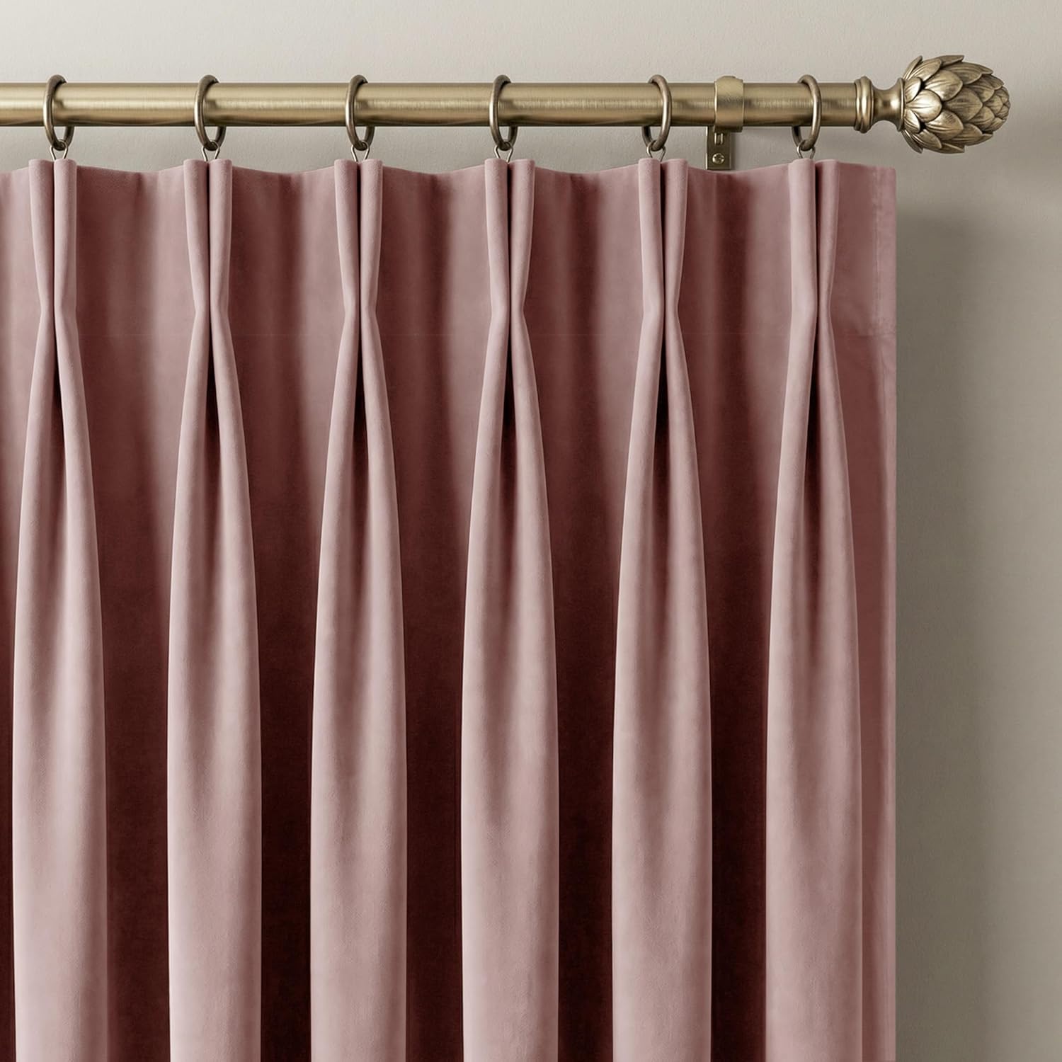 Dusty rose velvet pinch pleat curtains hung on a brass rod with rings and artichoke finial.
