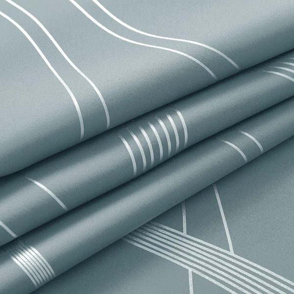 Dusty teal fabric with shiny silver geometric lines, folded to display the unique pattern and subtle woven texture.