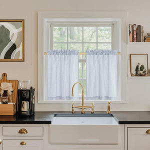 White and light blue striped cafe curtains with ruffled top over kitchen sink window.