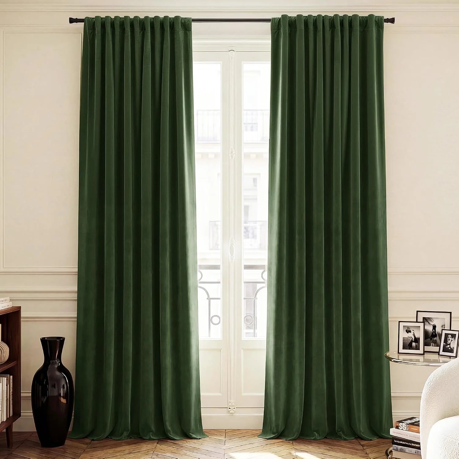 Forest green velvet pleated curtains hanging on a black rod in a bright elegant room