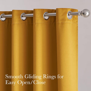 Close-up of a vibrant gold fabric curtain panel with shiny silver grommets for smooth gliding on a metal rod.