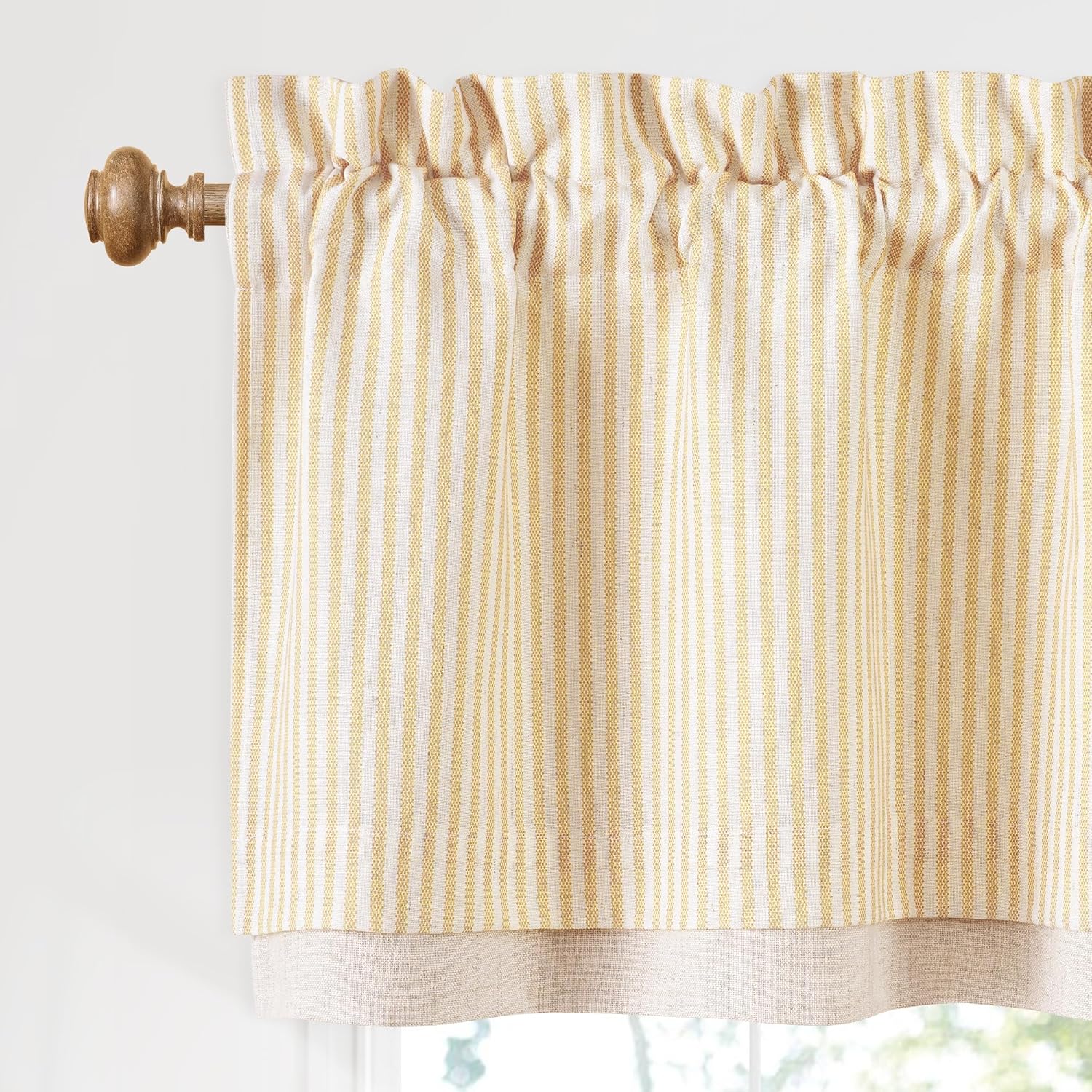 Gold and white striped valance with rod pocket top and natural linen bottom, hung on a wooden rod.