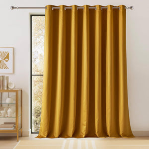 Golden yellow velvet blackout curtain panel with silver grommet top hanging on a window rod.