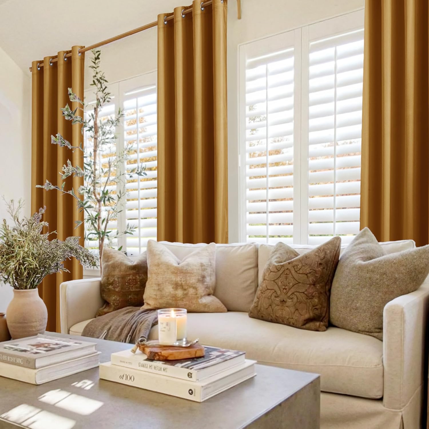 Golden yellow grommet top curtains hanging on a rod in a modern living room with white shutters and neutral furniture.