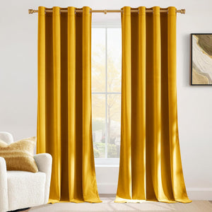 Golden yellow velvet blackout curtains with grommet top hanging on a gold rod in a modern room