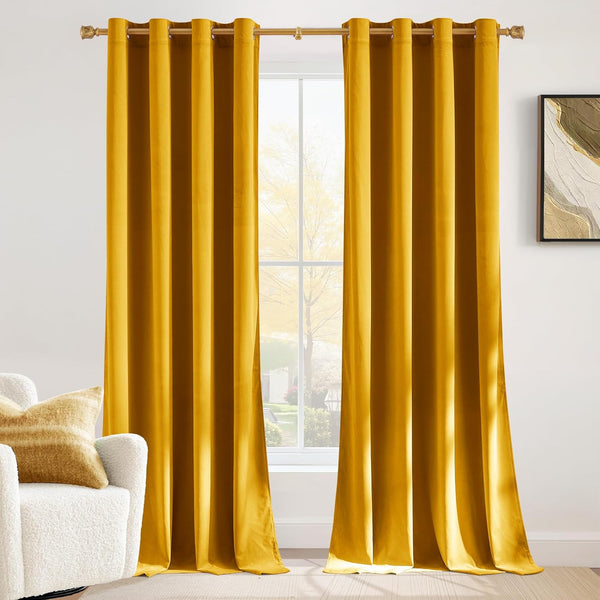 Golden yellow velvet blackout curtains with grommet top hanging on a gold rod in a modern room