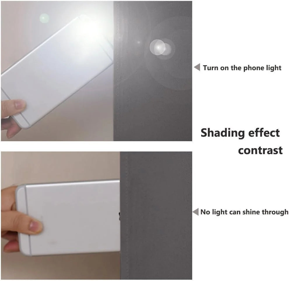 Hand holding a lit phone behind a gray blackout curtain showing no light bleed