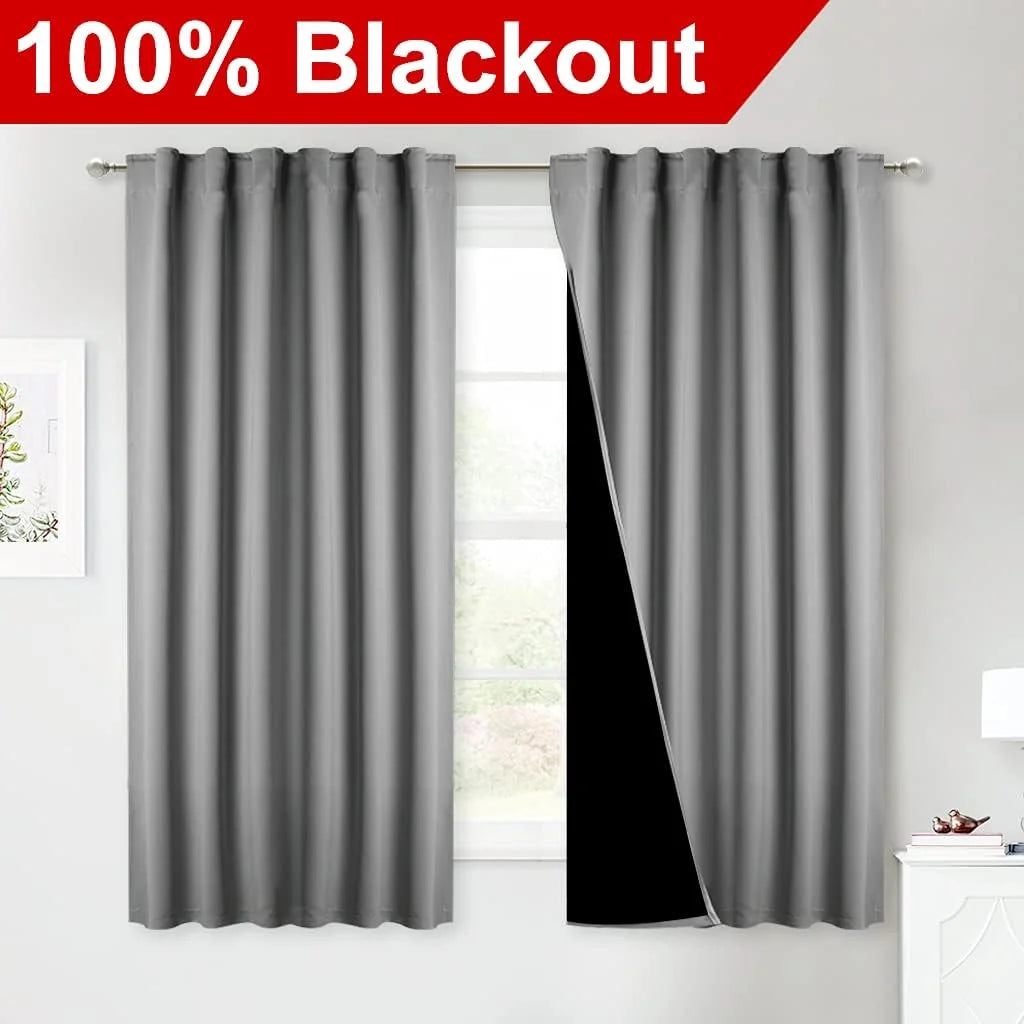 Gray 100% blackout curtains on a rod in a bright bedroom window display