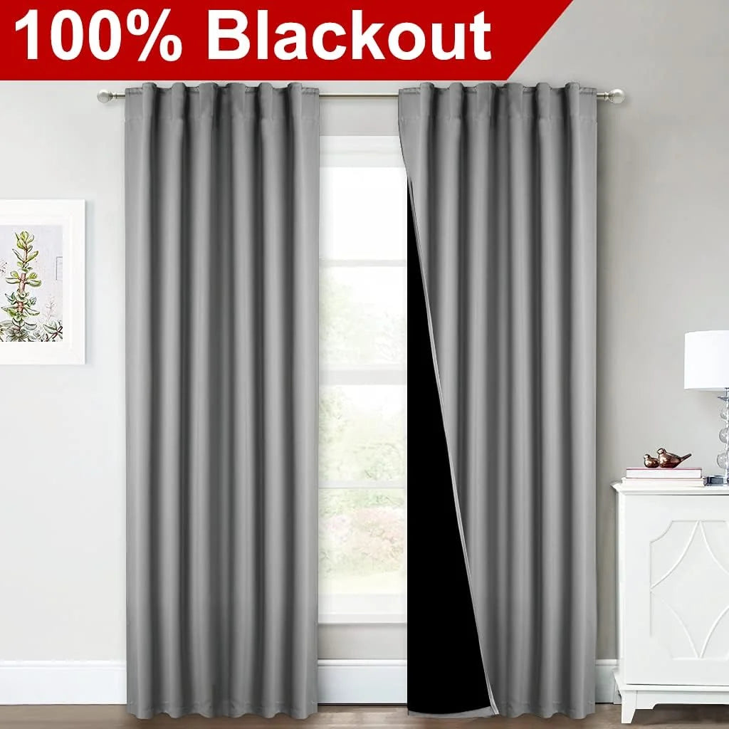 Gray blackout curtains on a bedroom window with pleated top and black lining
