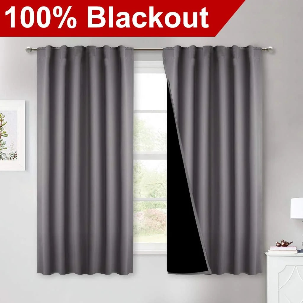 Gray blackout curtains on a silver rod with one panel pulled back to show black lining