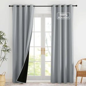 Light gray blackout curtains with grommet top hanging on a rod over white French doors, revealing a black lining.