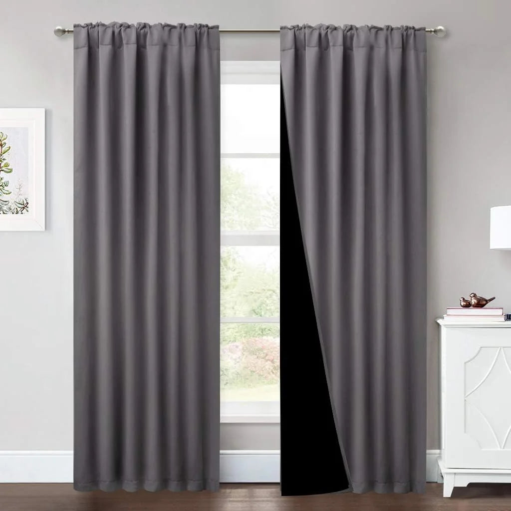 Gray blackout curtains with rod pocket top hanging in a bright modern room