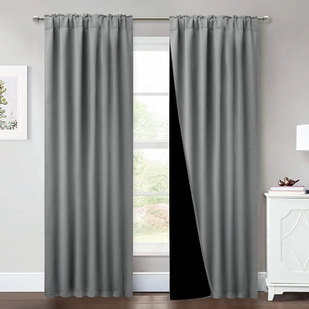 Gray rod pocket blackout curtains hanging in a bright modern bedroom window