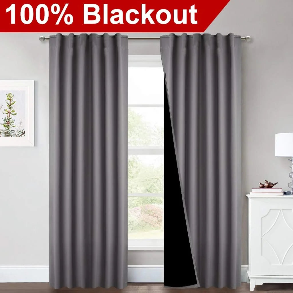 Gray blackout curtains on a silver rod in a bright modern room with one panel opened