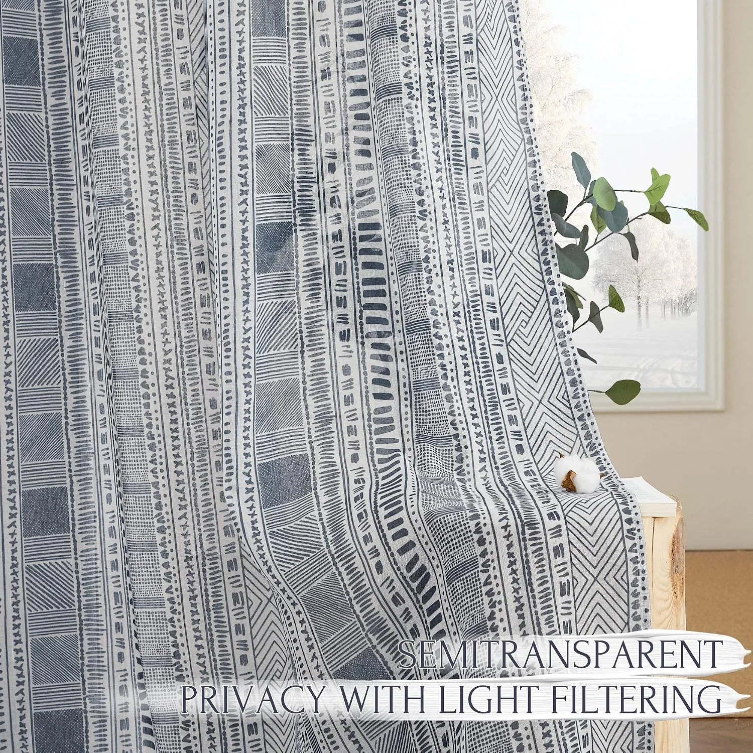 Gray semitransparent curtain with boho geometric stripe pattern by a bright window