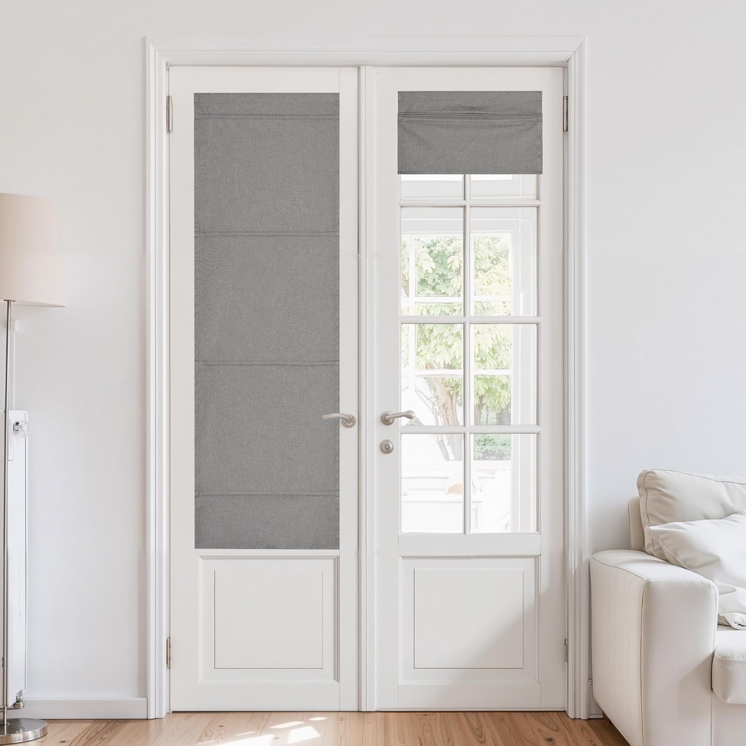 Textured gray flat-fold roman shades installed on white French doors in a bright living room.