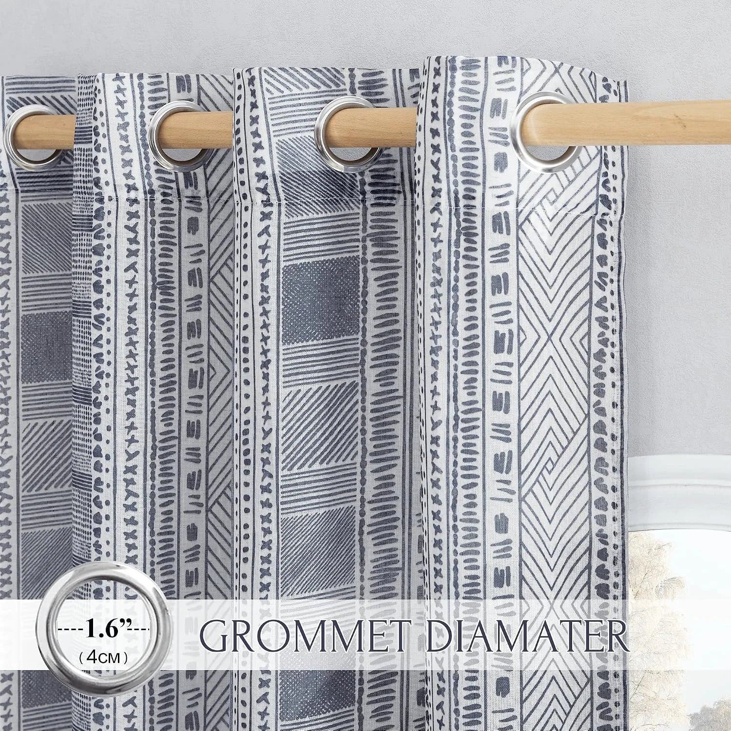 Gray and white geometric curtain panel with silver grommets on a wooden rod