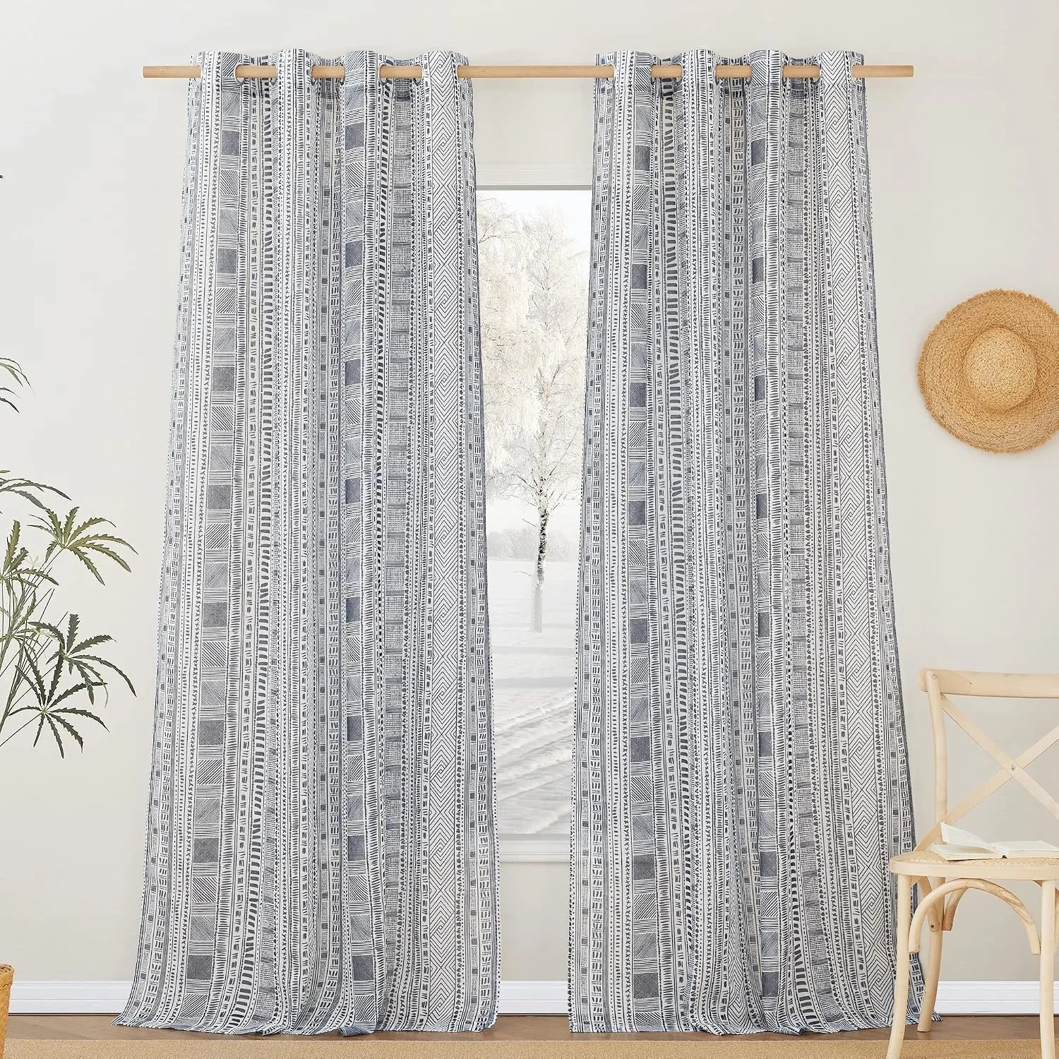 Gray and white geometric patterned curtains on a natural wood rod in a bright room
