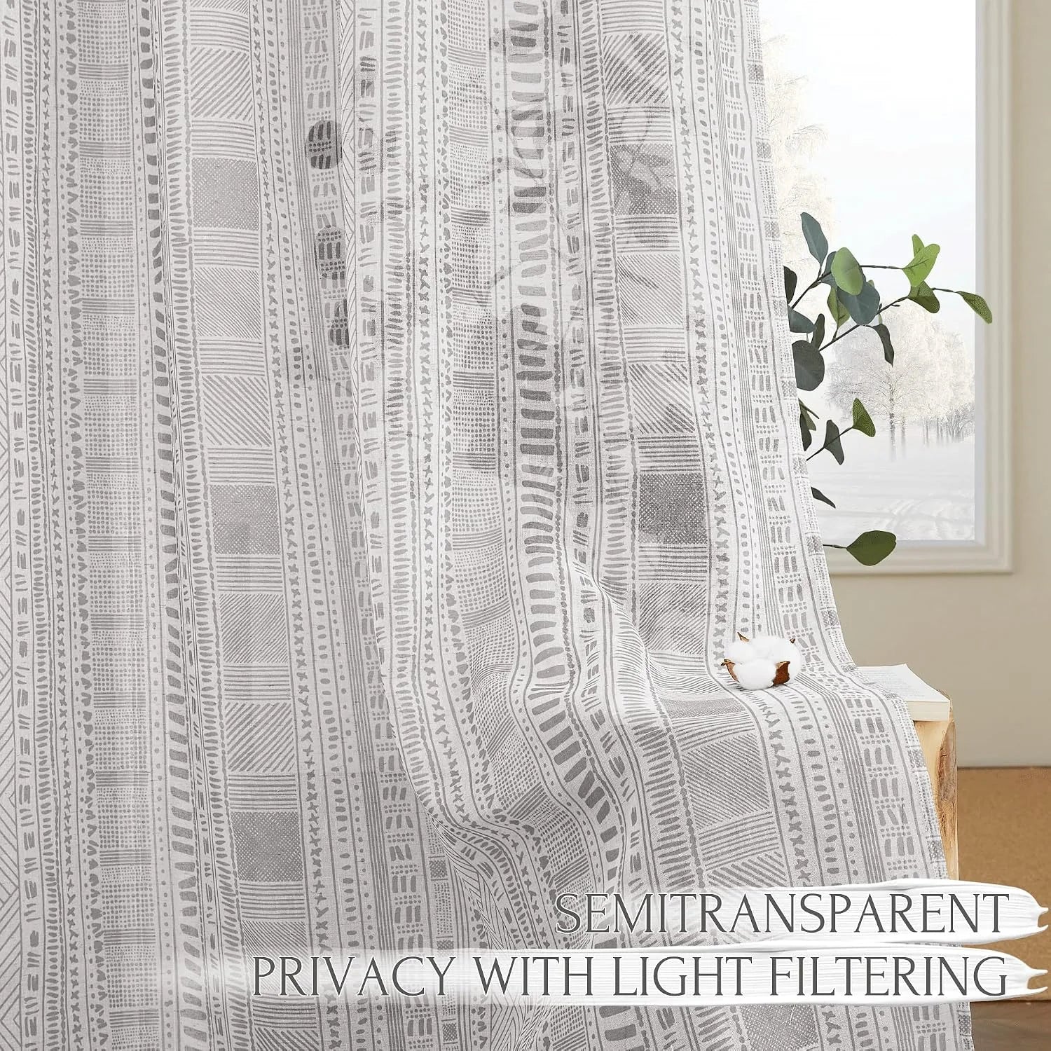 Gray geometric semi-sheer curtain panel filtering light by a bright window
