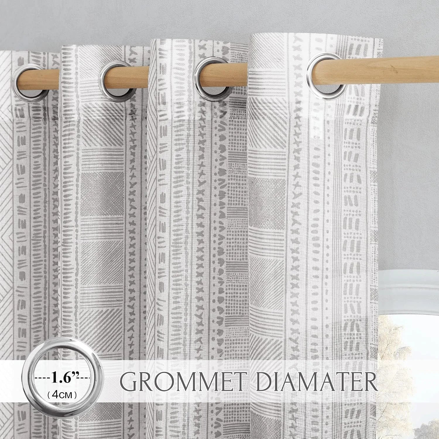 Gray geometric sheer curtain panel with silver grommets on a natural wood rod