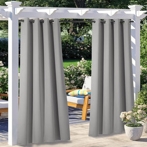 Solid gray outdoor pergola curtains with black grommet rings hanging on a sunny patio deck.