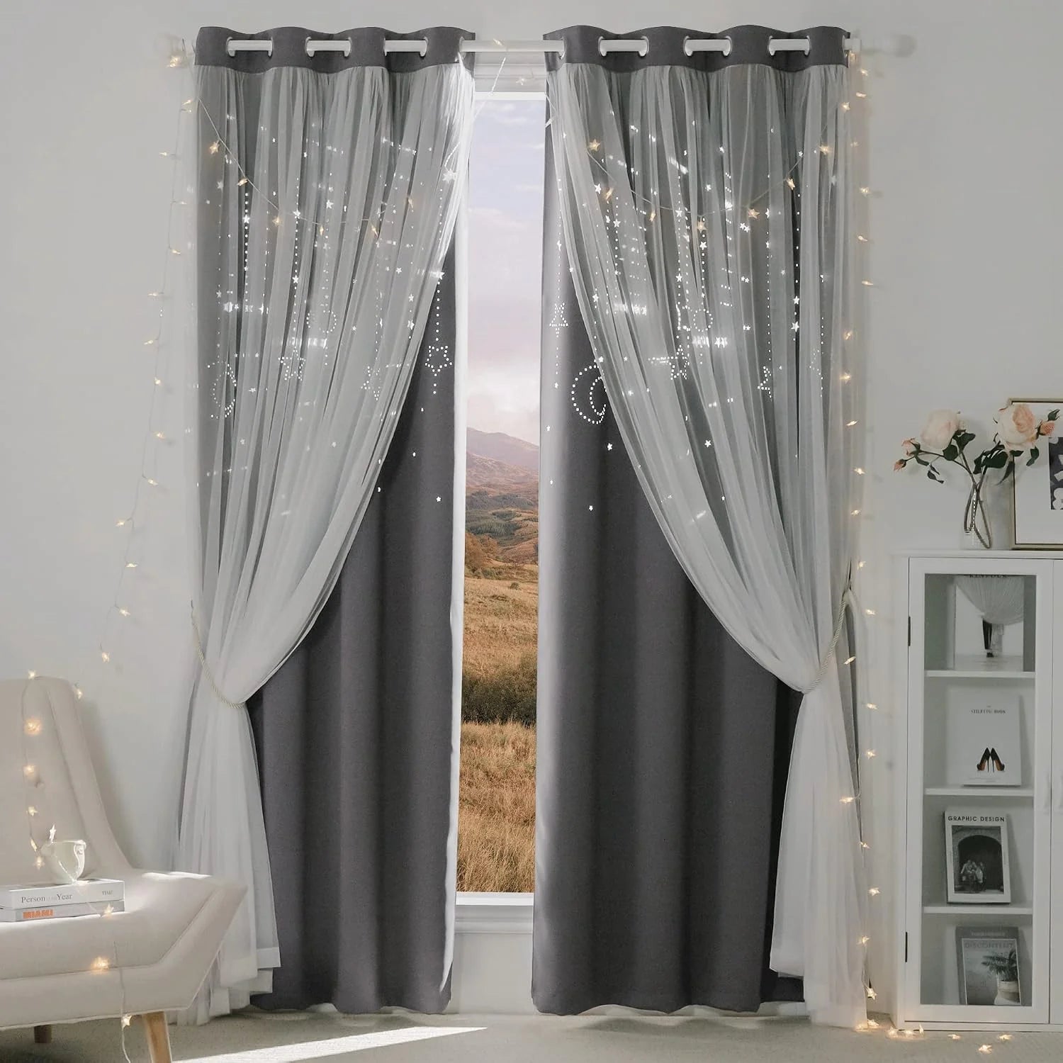 Gray blackout curtains with white sheer star overlay and fairy lights in a bedroom