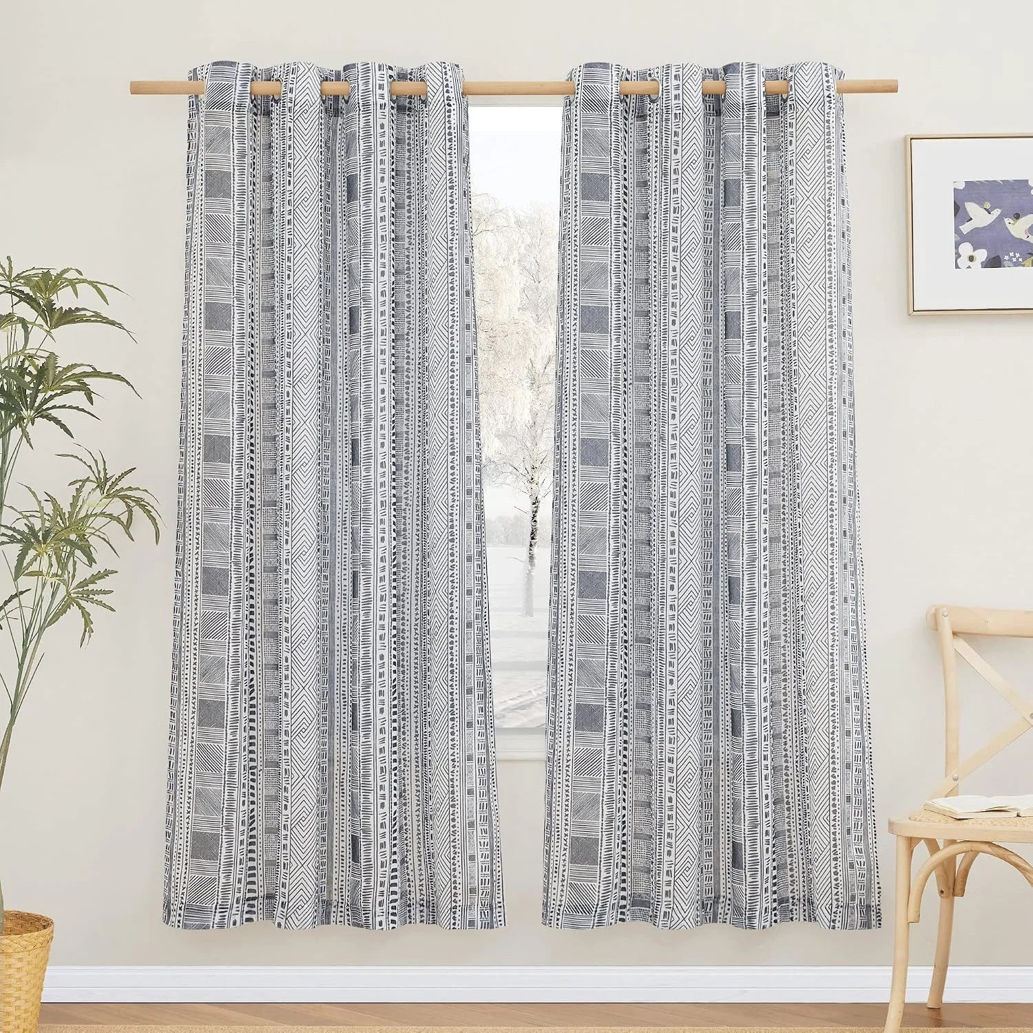Gray and white tribal print curtains on a wooden rod in a bright modern room
