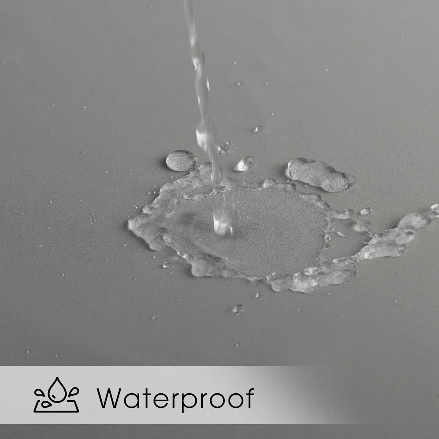 Water splashing and beading on gray fabric, highlighting its waterproof and water-resistant surface.