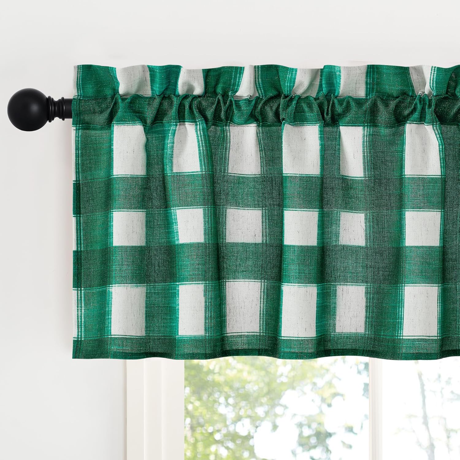 Green and white gingham check valance with a rod pocket hanging on a black curtain rod over a window.