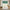 Green and white gingham rod pocket valance with gathered top hanging in a farmhouse kitchen.